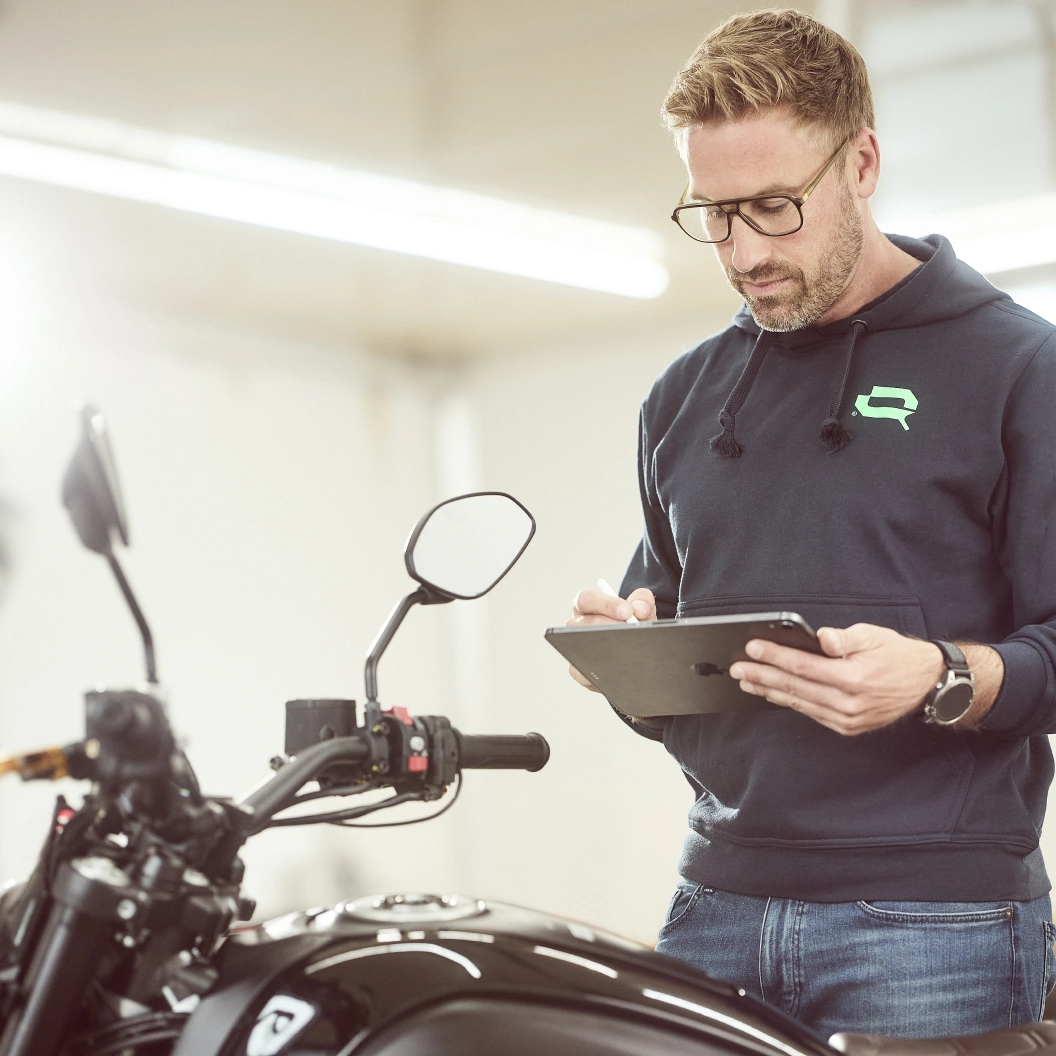 Kfz-Gutachter bei Lotterschmid München mit Tablet bei der Fahrzeugprüfung