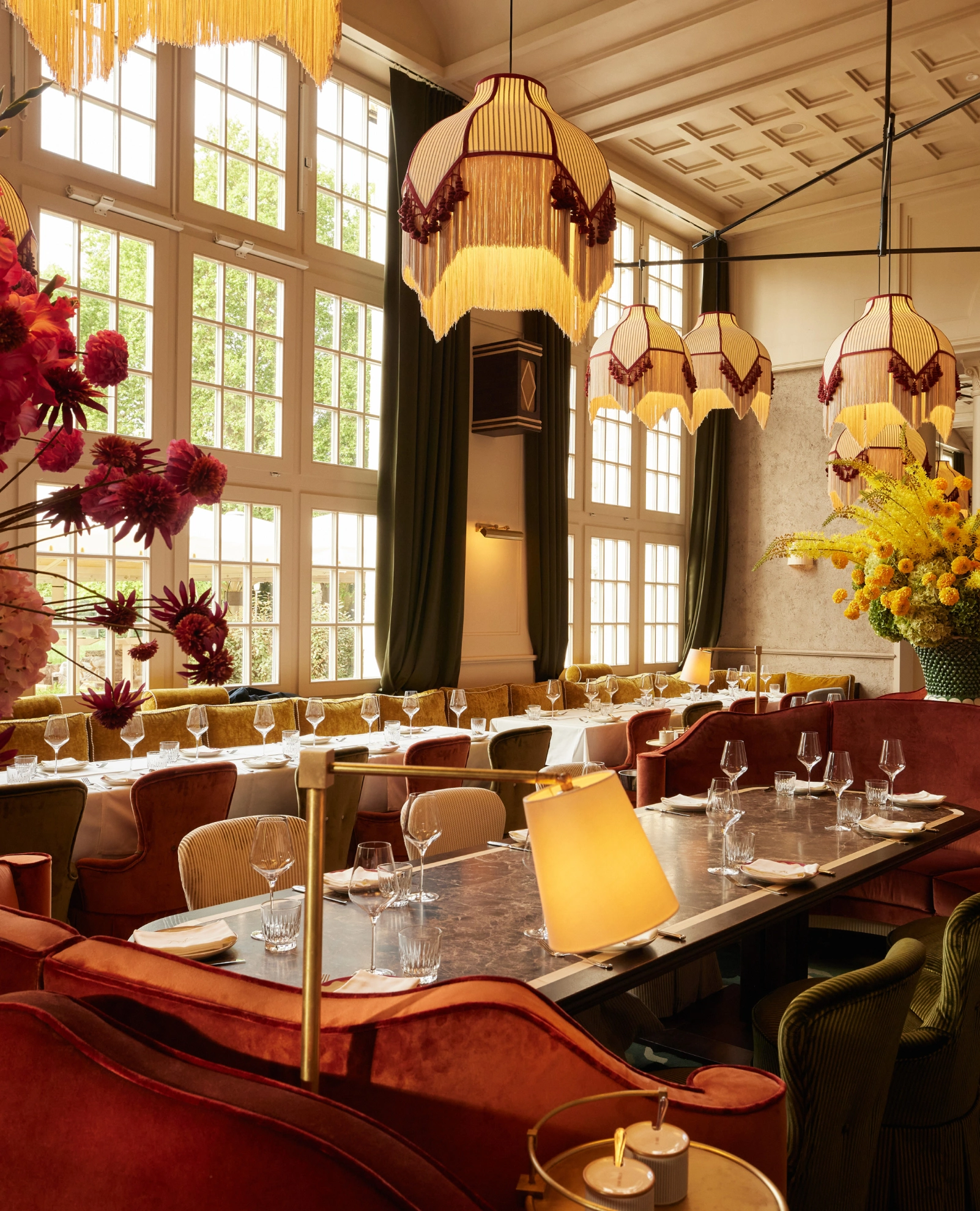 Opulenter Innenraum des Restaurant Pellicano München mit Fransenlampen und Samtstühlen