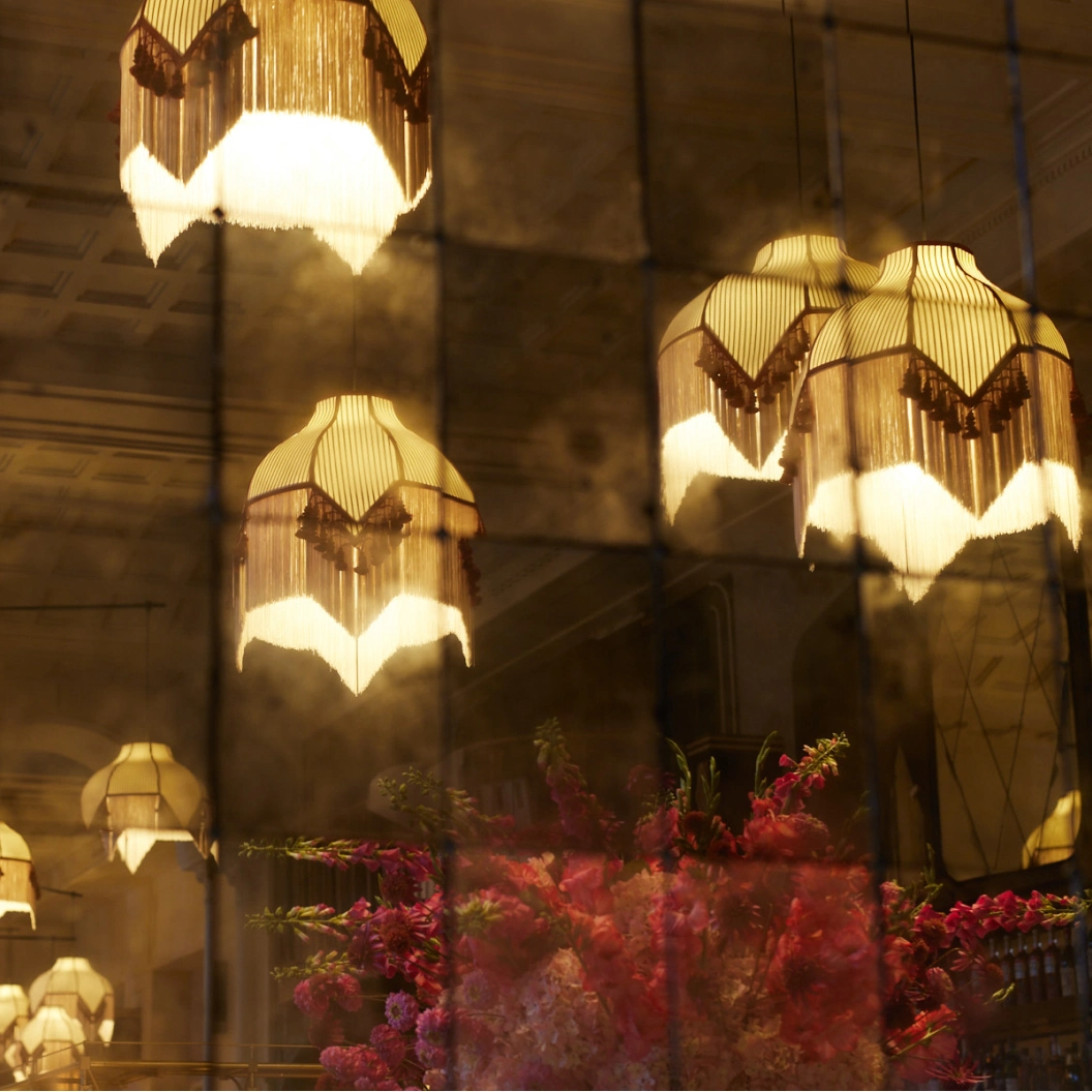 Beleuchtungsdetail mit Fransenlampen und Blumen im Restaurant Pellicano München